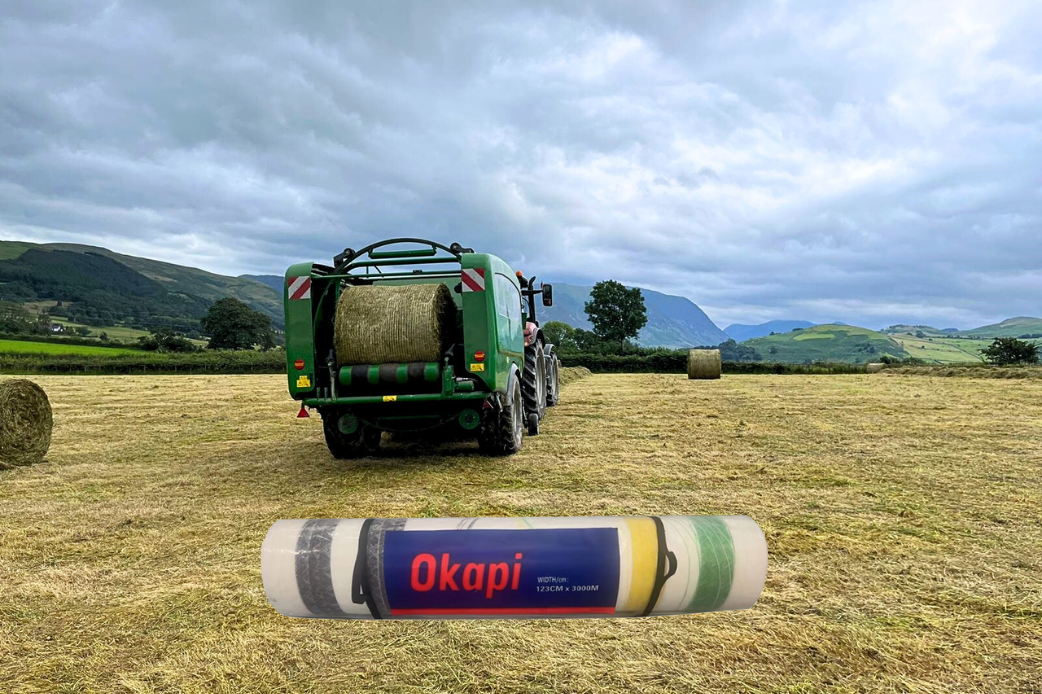 OKAPI bale net wrap with an agricultural baler in the background — ZEUS graphic