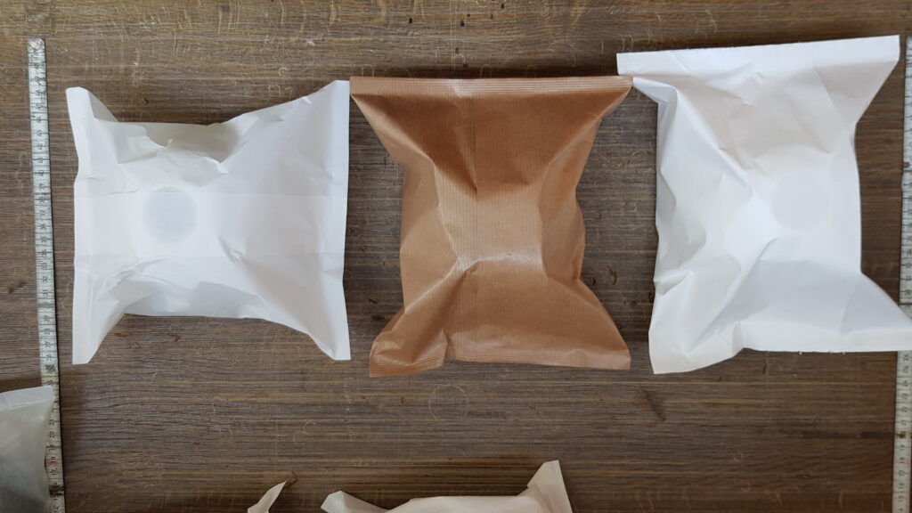 Próbki kloszy lamp zapakowanych w biały i brązowy papier
