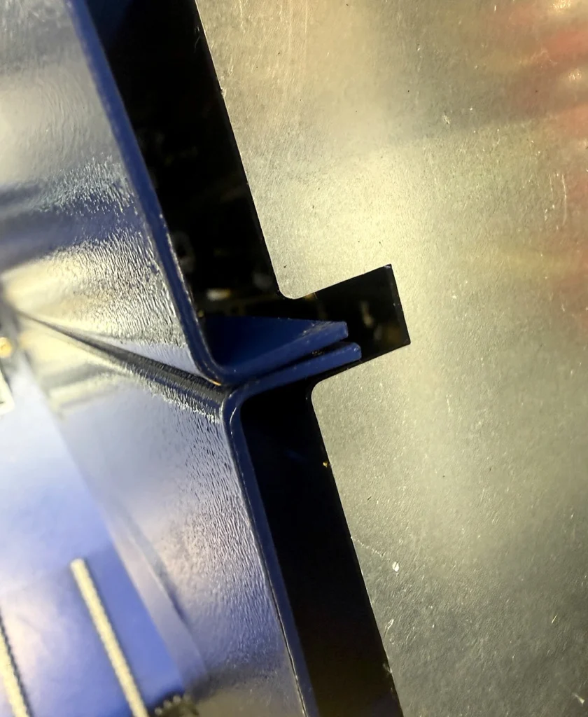 Edge of a folded-sheet mast component on the other manufacturer's wrapper
