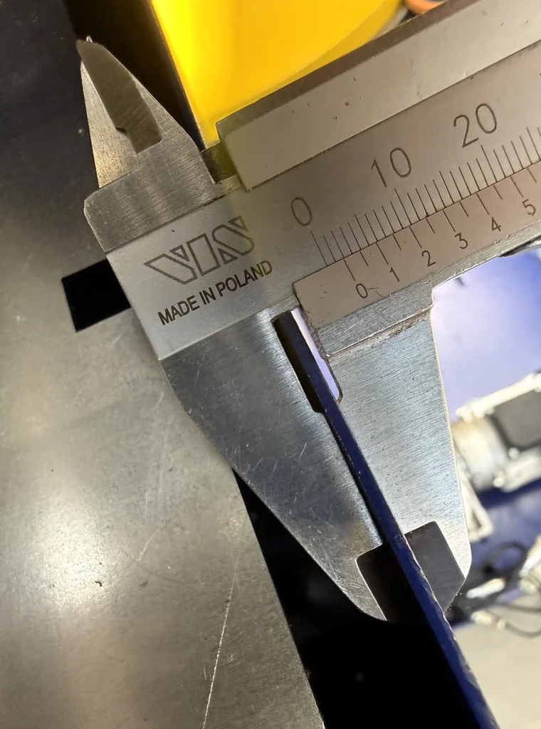 Calliper measuring the edge of a folded-sheet mast component on the other manufacturer's machine